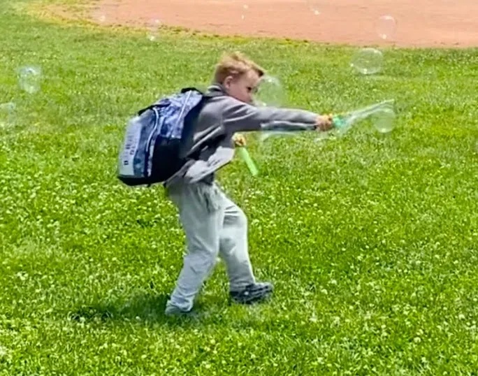 A bright kid relaxes with some after-school bubble-blowing.